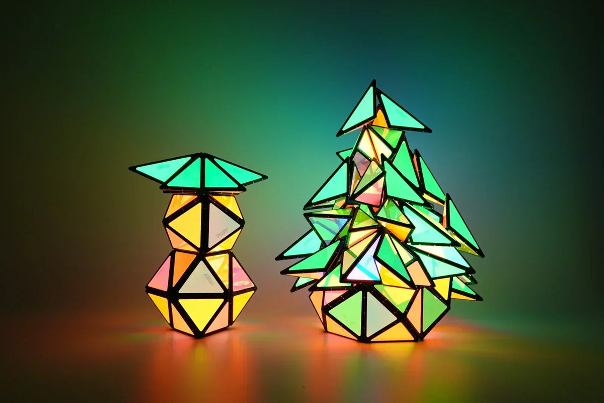 TOSY Magnetic Pyramid Glow arranged in Christmas tree shapes, colorful glowing magnetic building toy creating festive holiday patterns with illuminated pieces