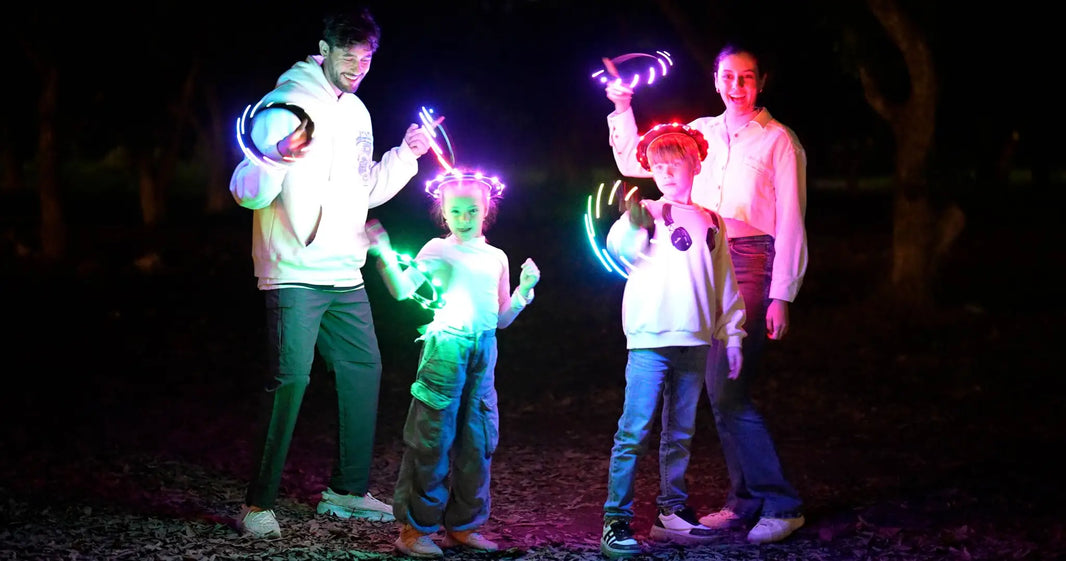 Kids and parents enjoying outdoor night play with glowing LED flying rings